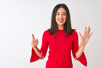 Young beautiful chinese woman wearing red dress standing over isolated white background showing and pointing up with fingers number six while smiling confident and happy.