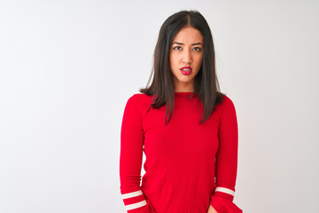 Young beautiful chinese woman wearing red dress standing over isolated white background skeptic and nervous, disapproving expression on face with crossed arms. Negative person.