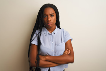 Young african american woman wearing striped shirt standing over isolated white background skeptic and nervous, disapproving expression on face with crossed arms. Negative person.