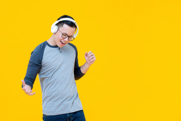 Asian man wearing headphones listening to music and moving body