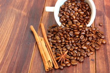 aroma roasted coffee beans in white cup with cinnamon,anise on retro wood floor
