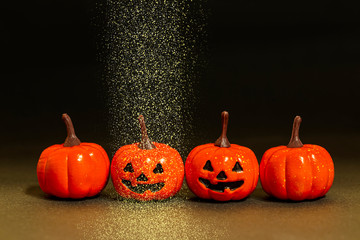 黒バックと笑う小さなカボチャとゴールドの砂