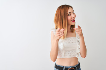 Beautiful redhead woman wearing casual t-shirt standing over isolated white background pointing fingers to camera with happy and funny face. Good energy and vibes.