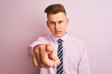 Young handsome businessman wearing shirt and tie standing over isolated pink background pointing displeased and frustrated to the camera, angry and furious with you