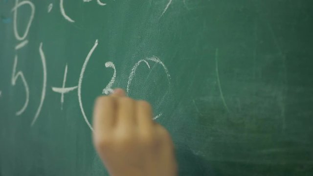Maths' chalkboard. Hand's writing simple mathematical equation