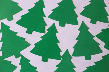 Christmas mood flat lay. Happy New Year flat lay on the paper. Green Christmas trees pattern on white paper