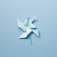 Blue paper pinwheel on blue background
