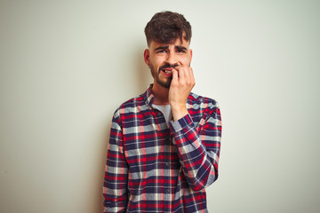 Young man wearing casual shirt standing over isolated white background looking stressed and nervous...