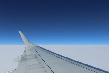 Fototapeta na wymiar Plane wing above clouds