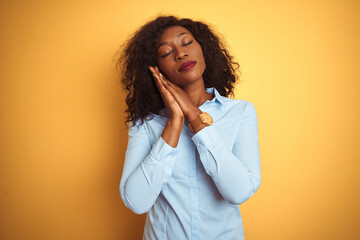 African american businesswoman wearing elegant shirt over isolated yellow background sleeping tired dreaming and posing with hands together while smiling with closed eyes.