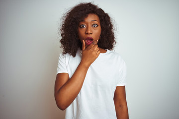 Fototapeta na wymiar Young african american woman wearing t-shirt standing over isolated white background Looking fascinated with disbelief, surprise and amazed expression with hands on chin