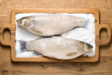 Fresh "grass carp" fish on the kitchen board.