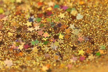 Christmas and New Year background. Stars and golden glitter .Golden shiny macro texture.Winter holidays background