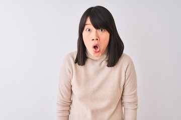 Young beautiful chinese woman wearing turtleneck sweater over isolated white background afraid and shocked with surprise expression, fear and excited face.