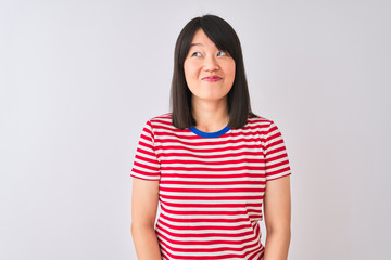 Fototapeta premium Young beautiful chinese woman wearing red striped t-shirt over isolated white background smiling looking to the side and staring away thinking.