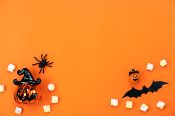 Table top view aerial image of decorations Happy Halloween day background holiday concept.Flat lay objects to party pumpkins and spider with candy sweet on orange  paper.Copy space for text.