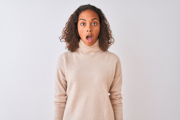 Young brazilian woman wearing turtleneck sweater standing over isolated white background afraid and shocked with surprise expression, fear and excited face.