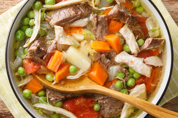 Slow Cooker Belgian Booyah soup with vegetables and meat close-up in a bowl. Horizontal top view