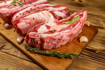 Raw pork ribs with spices, garlic and rosemary on wooden table
