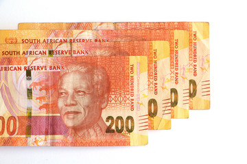 South African money, currency, orange two hundred rand notes stacked and isolated on a white background featuring Nelson Mandela