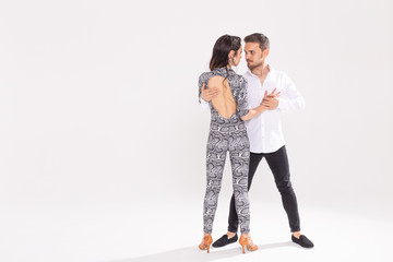 Social dance, bachata, kizomba, zouk, tango concept - Man hugs woman while dancing over white background with copy space