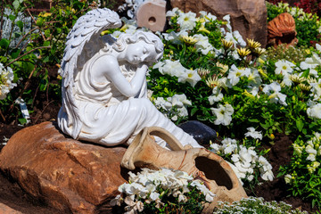 White marble statue of angel in ornamental garden