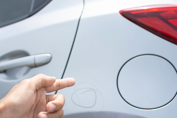 Man inspection Pointing finger trace marking point with car Fuel tank cap waiting for repair on car dealership in garage parked in showroom of automobile automotive for insurance