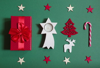Flat lay of red Christmas gift and Christmas ornaments against the green background