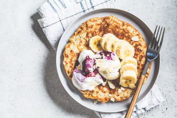 Sweet oatmeal pancake with banana and yogurt. Healthy breakfast concept.