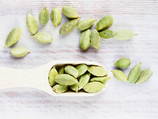 Spice Green cardamom (Elettaria cardamomum) in a scoop on a brown wooden background