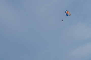 Fototapeta na wymiar Parasailing. Man parachuting behind a boat