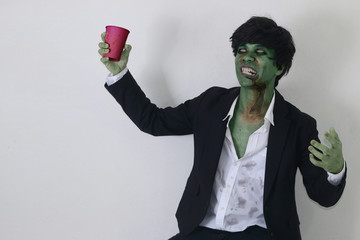 Business zombie man holding party cup.