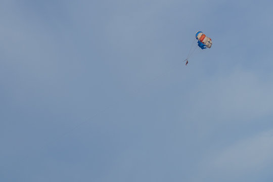 Parasailing. Man parachuting behind a boat