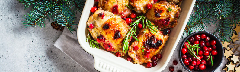 Christmas food. Baked Chicken meat with cranberries and rosemary in the oven dish, white...