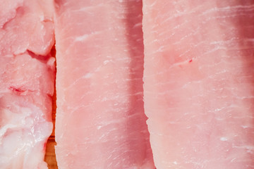 Uncooked slices of fresh pock meat on background.