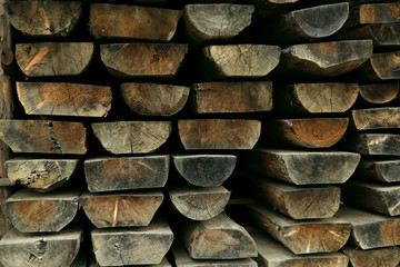 Background texture saw cut planks of hard wood. Drying boards in the open air. Close-up, horizontal, cropped shot, free space. Construction and woodworking concept.