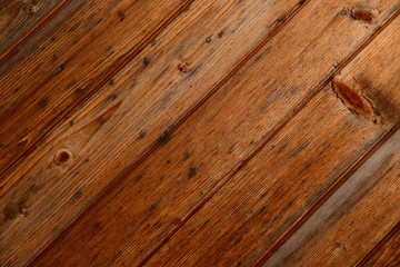 Abstract natural background. Top view on the surface of diagonal brown wooden planks. Close-up, horizontal, cropped shot, free space. Construction and woodworking concept.