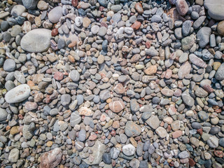 Pebbles texture. Colorful stones on the ground. Top view of Natural gravel on the summer beach.