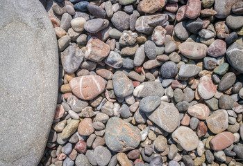 Pebbles texture. Colorful stones on the ground. Top view of Natural gravel on the summer beach. Stone with copy space for text.