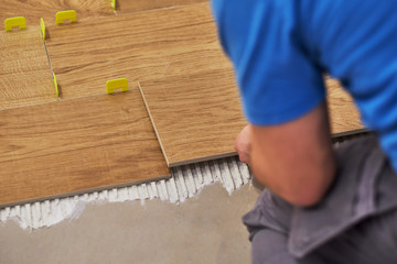close-up of handyman placing tile spacer. Placing the floor tiles. Home improvement