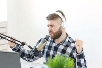 Music, dj, blogging and broadcasting concept - Male radio host with a funny expression