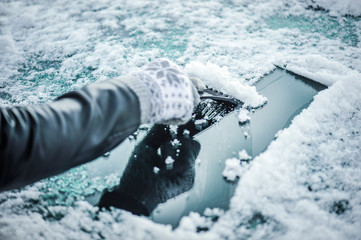 Removing snow from car windshield.  Clean car window in winter from snow.