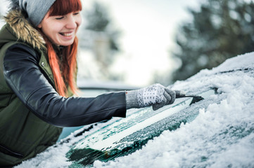 Clean car window from snow. Winter windshield car cleaning. Removing snow from window.