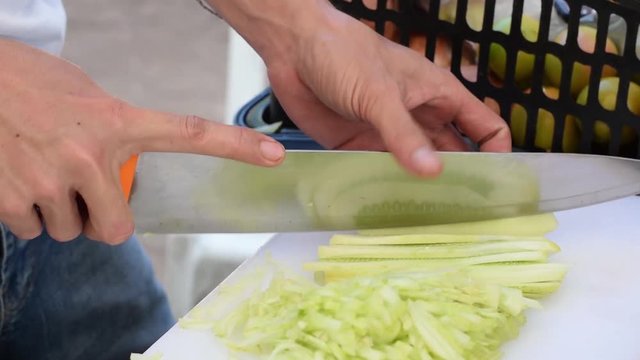 chef cook chopping cucumber. close up