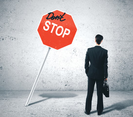 Businessman looking on dont stop sign