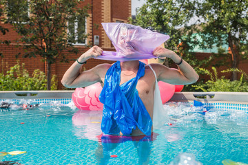 Ecology, plastic trash, environmental emergency and water pollution - Screaming man with a plastic bag over his head in a dirty swimming pool