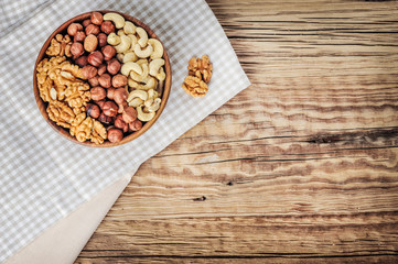 Top view on mixed nuts. Hazelnuts, cashew and walnuts in bowl on table.