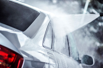 Manual car washing with water jet. Car wash detail. Clean car at wash station.