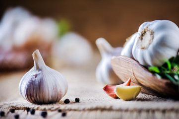 Garlic cloves on rustic table. Garlic in wooden bowl. Fresh peeled garlic and  bulbs.