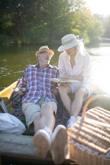 Couple chilling in boat and reading book at the weekend